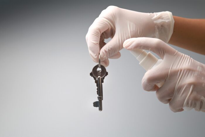 Woman's,Hands,With,Rubber,Gloves,Clean,And,Disinfects,House,Keys
